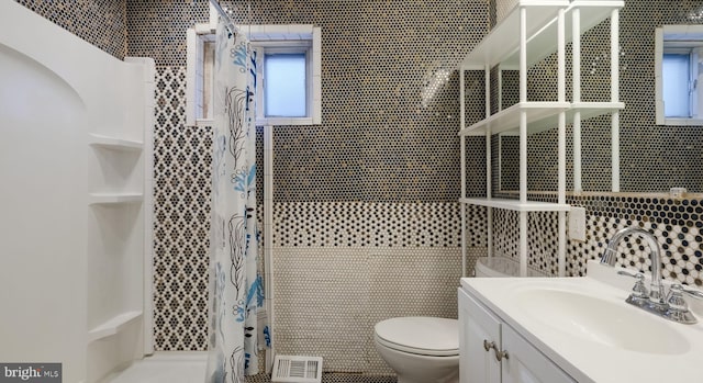 bathroom with a shower with curtain, toilet, tile walls, and vanity