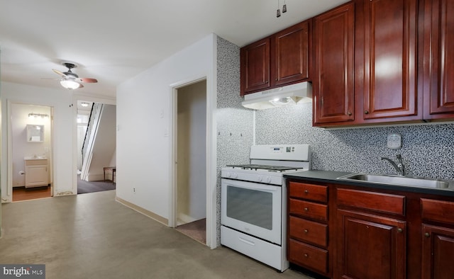 kitchen with white gas range oven, backsplash, ceiling fan, and sink