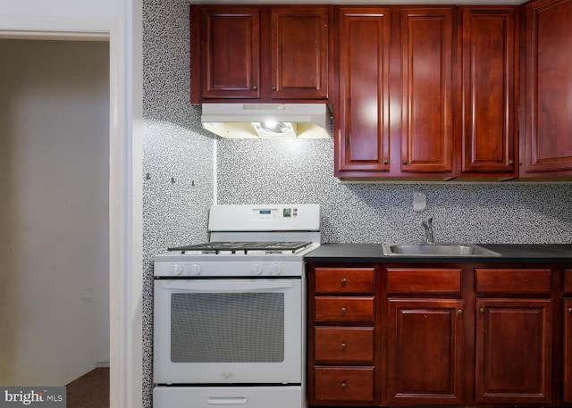 kitchen with backsplash, white gas range, and sink