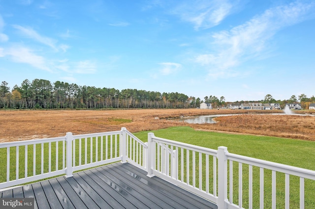 wooden terrace featuring a water view and a yard