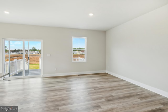 unfurnished room featuring plenty of natural light and light wood-type flooring