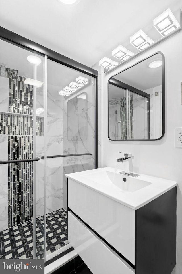 bathroom with tile patterned flooring, vanity, and walk in shower