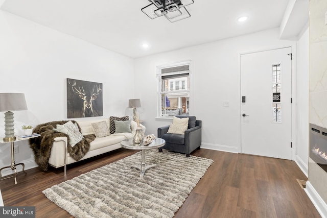 living room with dark hardwood / wood-style flooring and a high end fireplace