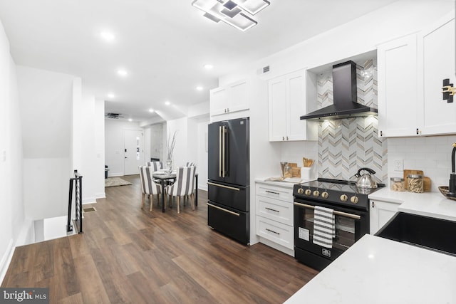 kitchen with range with electric stovetop, white cabinetry, high end fridge, and wall chimney range hood