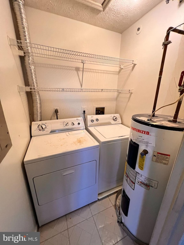 laundry area featuring washer and dryer, light tile patterned flooring, electric water heater, and a textured ceiling