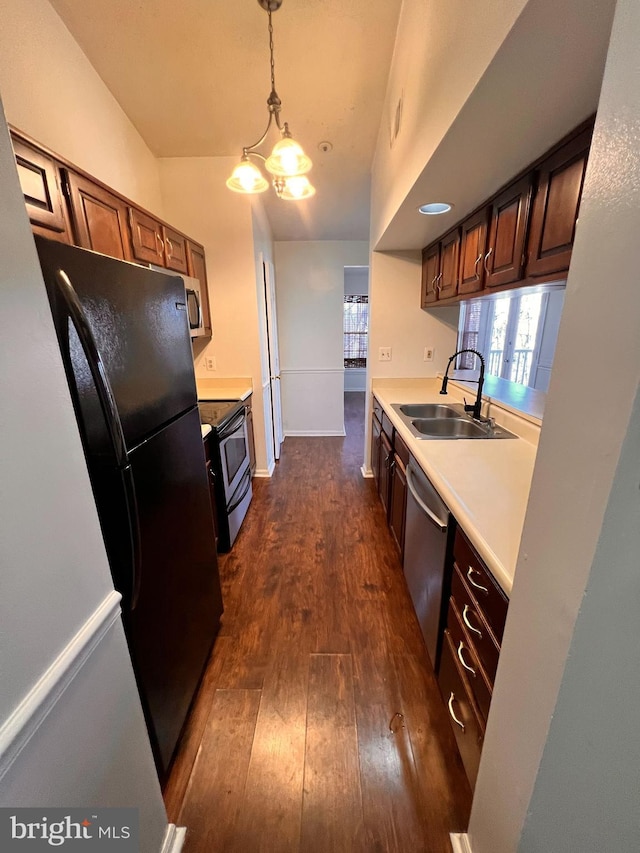 kitchen featuring black appliances, sink, pendant lighting, an inviting chandelier, and dark hardwood / wood-style floors