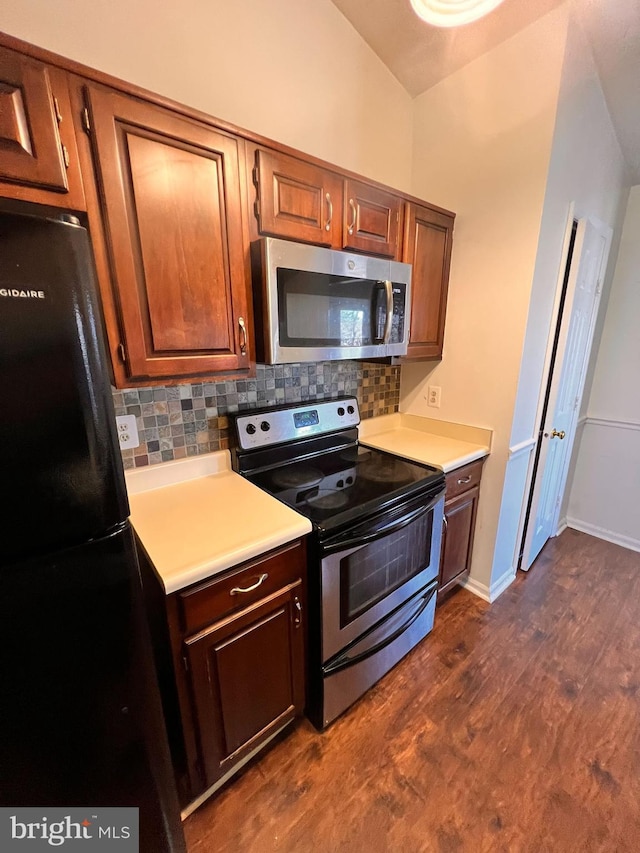 kitchen featuring tasteful backsplash, lofted ceiling, stainless steel appliances, and dark wood-type flooring