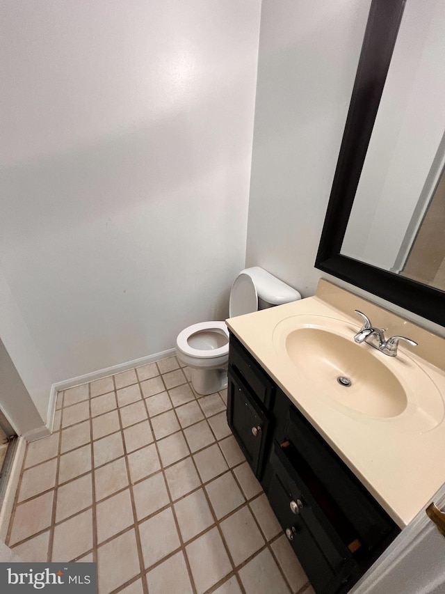 bathroom with toilet, vanity, and tile patterned floors