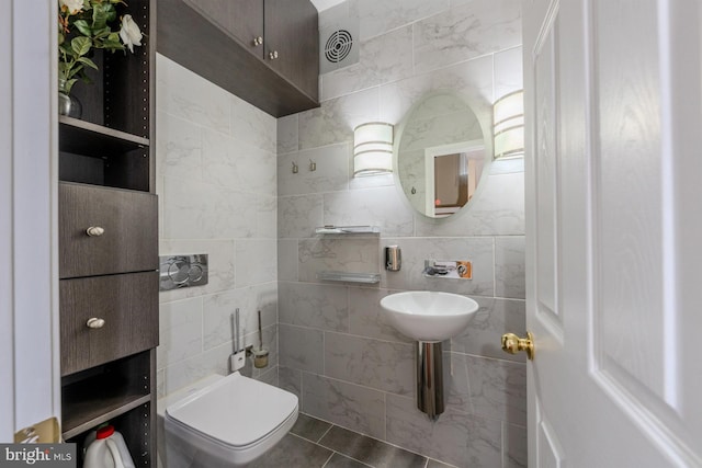 bathroom with tile patterned floors, tile walls, and toilet