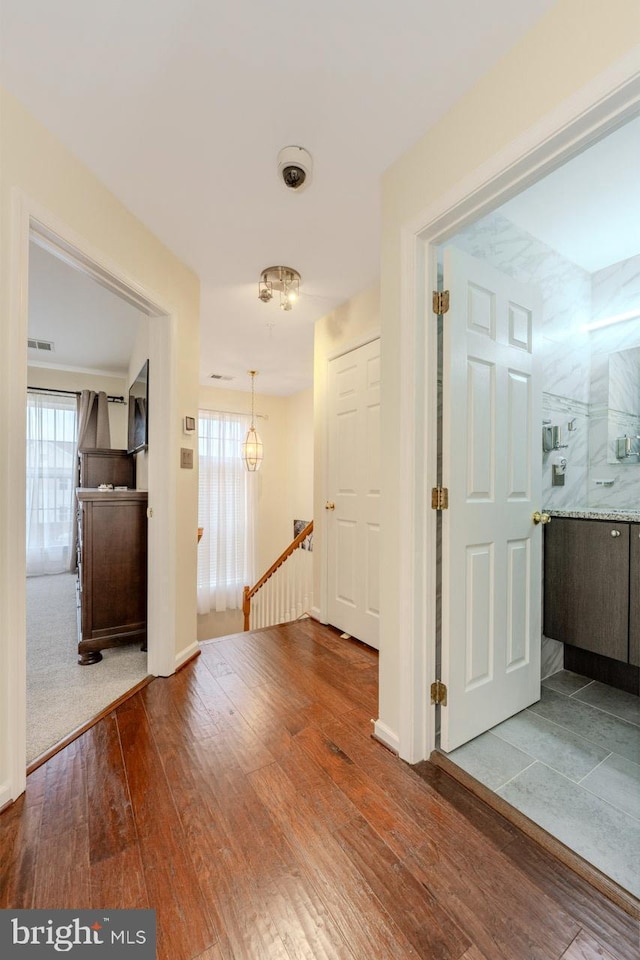 corridor with hardwood / wood-style flooring