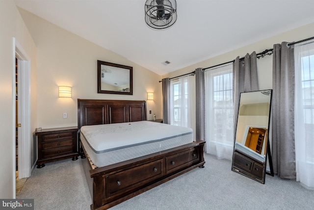 bedroom featuring multiple windows, light carpet, and lofted ceiling