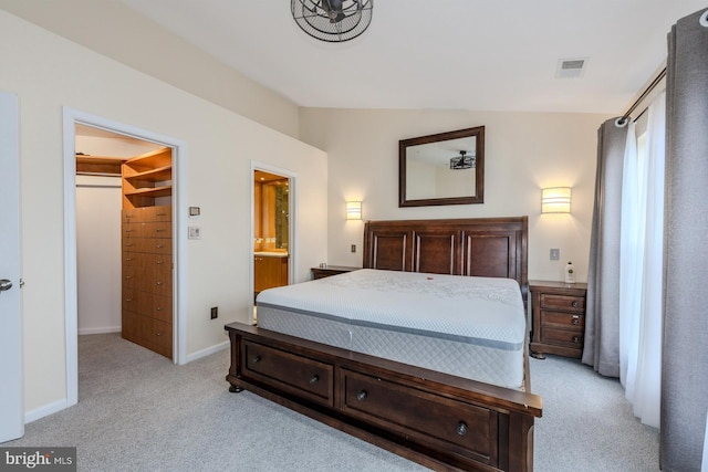 carpeted bedroom featuring connected bathroom and vaulted ceiling