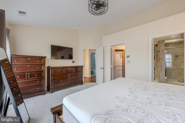 bedroom with connected bathroom and light colored carpet