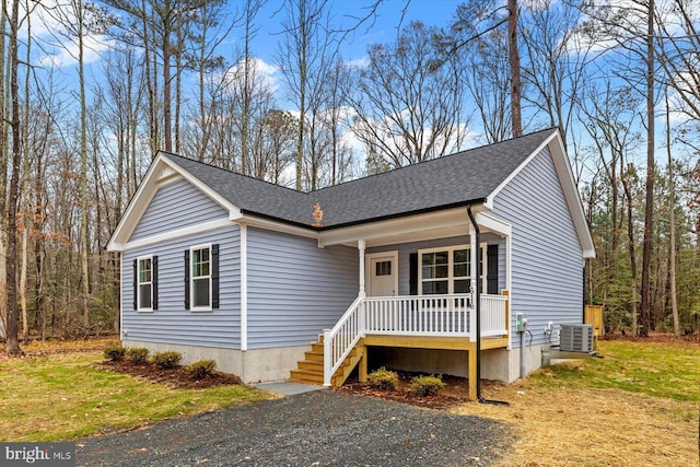 view of front of house with covered porch, a front lawn, and central AC unit