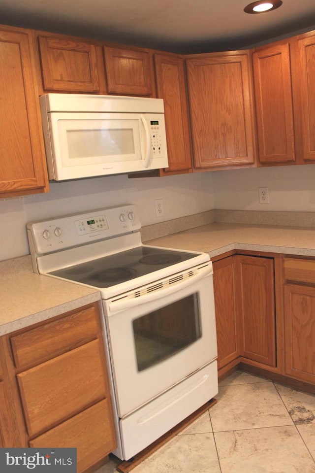 kitchen featuring white appliances and light tile patterned floors