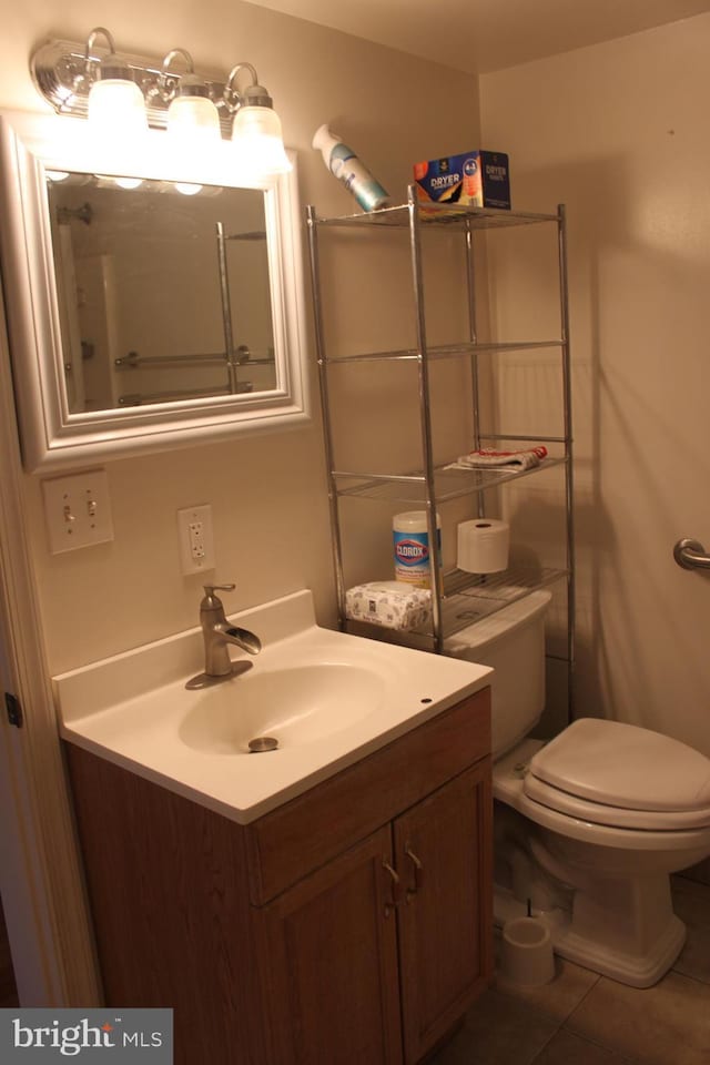 bathroom featuring toilet, vanity, and tile patterned floors