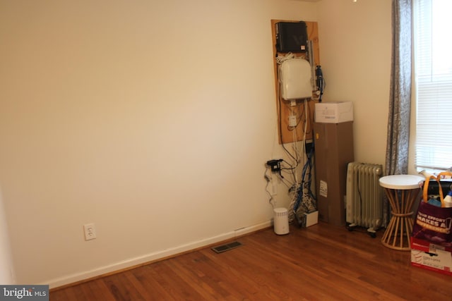 interior space featuring radiator heating unit and dark hardwood / wood-style flooring