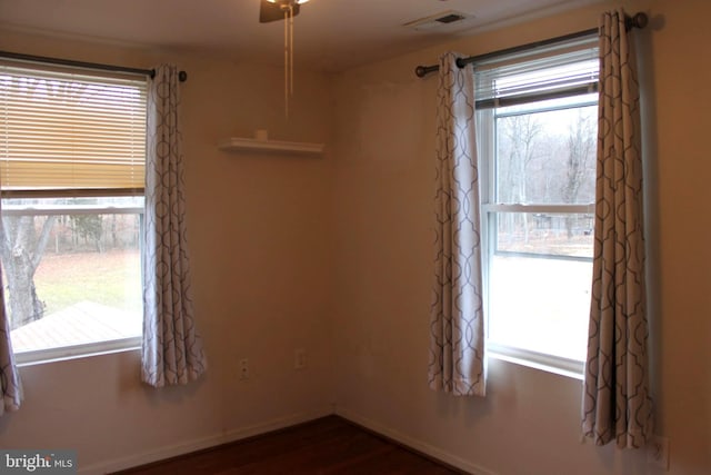 unfurnished room featuring a healthy amount of sunlight and dark hardwood / wood-style flooring