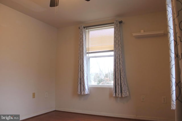 spare room featuring a wealth of natural light, ceiling fan, and hardwood / wood-style flooring