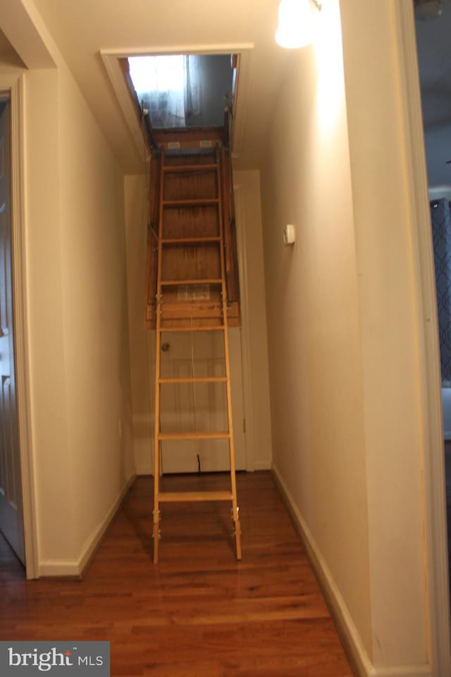 staircase featuring wood-type flooring and vaulted ceiling