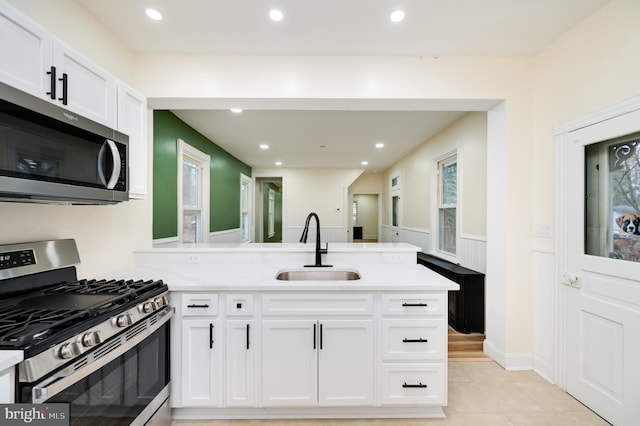 kitchen with sink, white cabinets, a healthy amount of sunlight, and appliances with stainless steel finishes