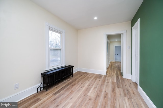 empty room featuring light wood-type flooring and radiator