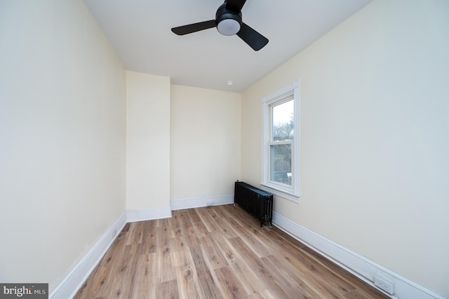 unfurnished room featuring radiator, ceiling fan, and light wood-type flooring