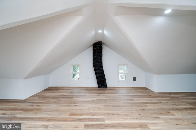 additional living space featuring light hardwood / wood-style floors and vaulted ceiling