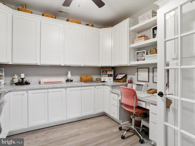 office space featuring ceiling fan, light wood-type flooring, and built in desk