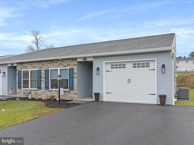 single story home with central air condition unit and a garage