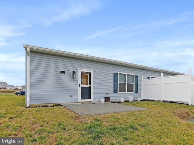 back of property featuring a patio and a lawn