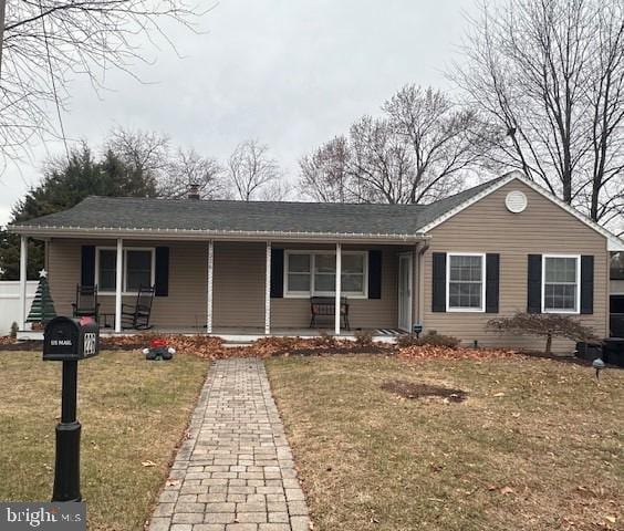 single story home with covered porch and a front yard