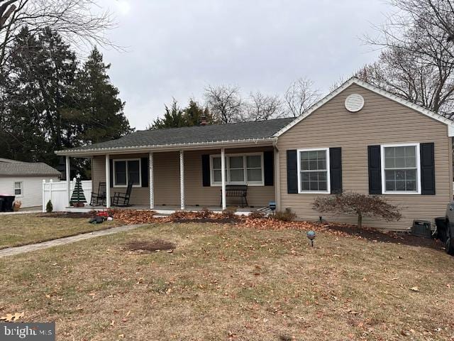 ranch-style home with covered porch and a front lawn