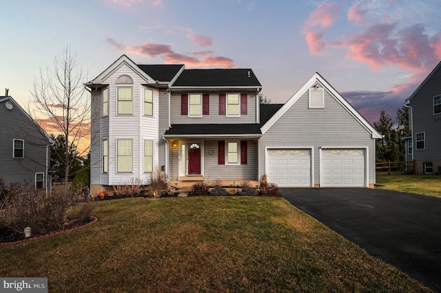 view of front of property with a garage and a lawn