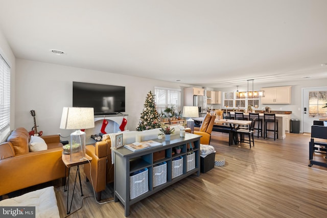 living room with a chandelier and light hardwood / wood-style floors