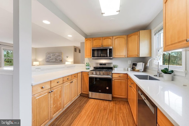 kitchen featuring sink, stainless steel appliances, light hardwood / wood-style flooring, and light brown cabinets