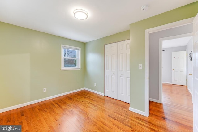 unfurnished bedroom with a closet and light hardwood / wood-style flooring