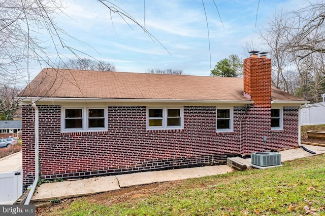 view of side of home with central air condition unit and a lawn