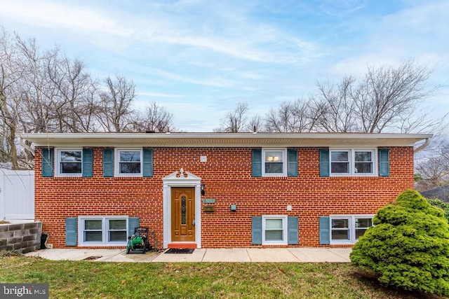 split foyer home with a front lawn and a patio area