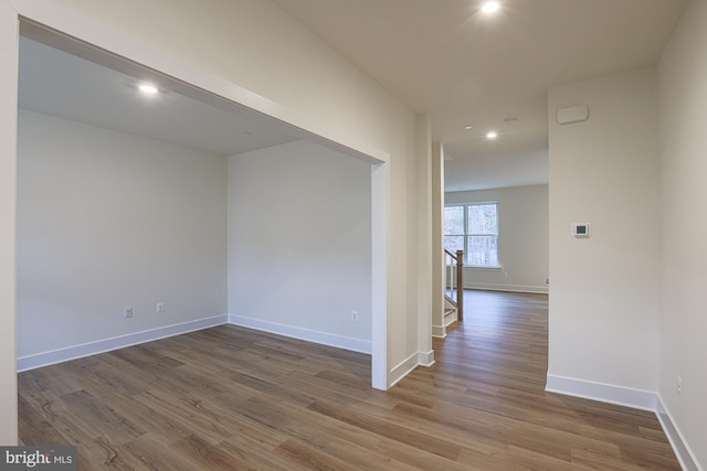 spare room featuring baseboards, wood finished floors, and recessed lighting