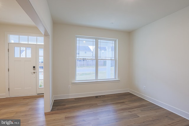 entrance foyer featuring visible vents, baseboards, and wood finished floors