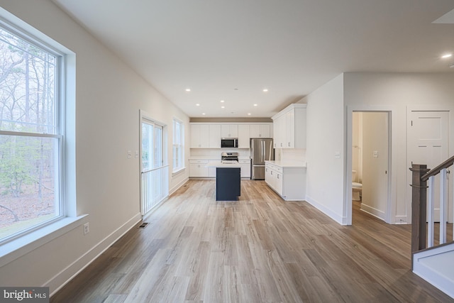 kitchen featuring stainless steel appliances, recessed lighting, light countertops, white cabinetry, and a kitchen island