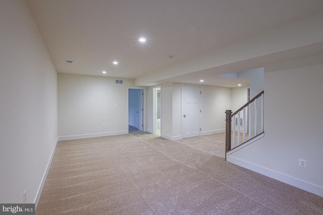 unfurnished room with light carpet, baseboards, stairway, and recessed lighting