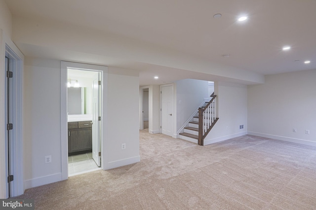 finished basement with stairs, light carpet, and recessed lighting