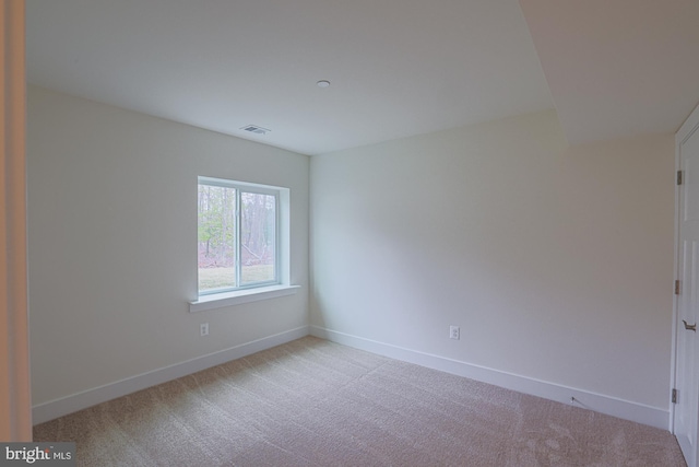 unfurnished room with carpet, visible vents, and baseboards