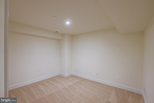 empty room with recessed lighting, light colored carpet, visible vents, and baseboards