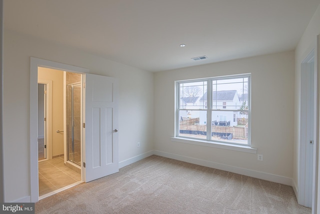 unfurnished bedroom with carpet floors, visible vents, and baseboards