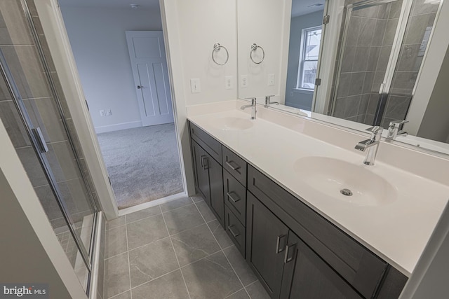 bathroom featuring tile patterned floors, a sink, a shower stall, and double vanity