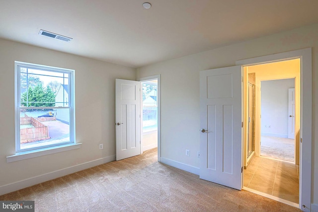 unfurnished bedroom with baseboards, visible vents, and carpet flooring