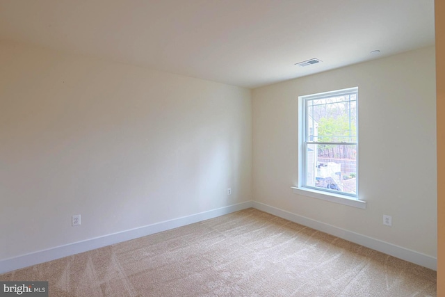 unfurnished room featuring light carpet, visible vents, and baseboards